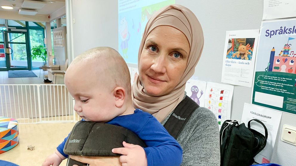 Porträttbild på mamman Carolina Nyrén som håller i sin bebis.