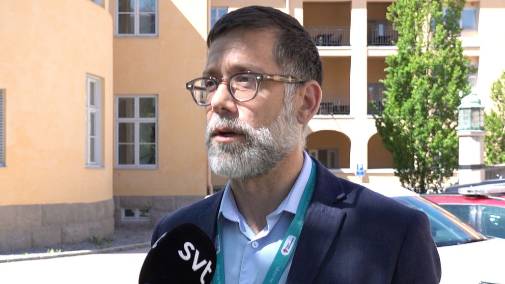 man framför gul fasad