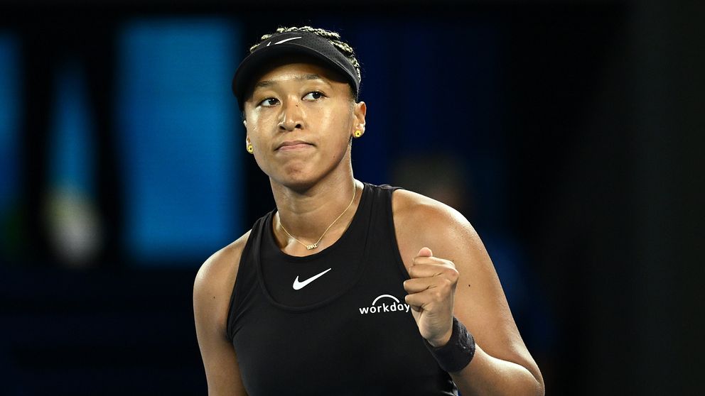 Tennis spelaren firar efter att ha vunnit en poäng i en match, klädd i en svart sportoutfit med en Nike-logotyp.