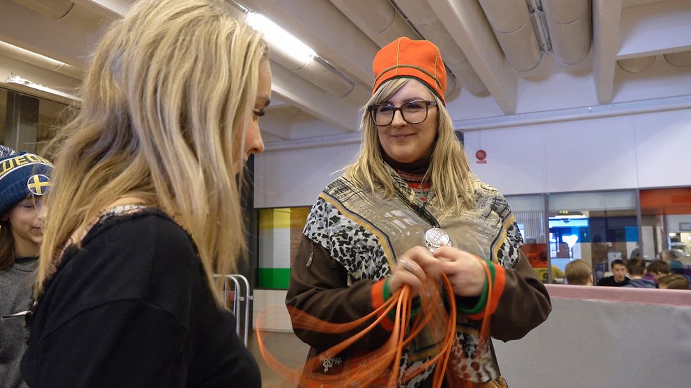 En kvinna med ett lasso som bär en sydsamisk kolt med en högstadieelev på Bergsåkers skola.