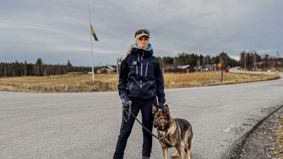 kvinna med hund som står i vägkorsning