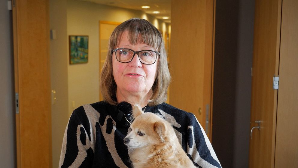 Kvinna med en liten hund i famnen