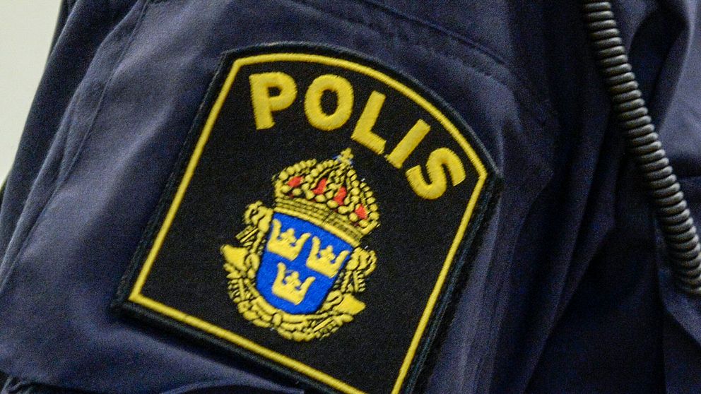 Närbild på en polisuniformsärm med polismärke