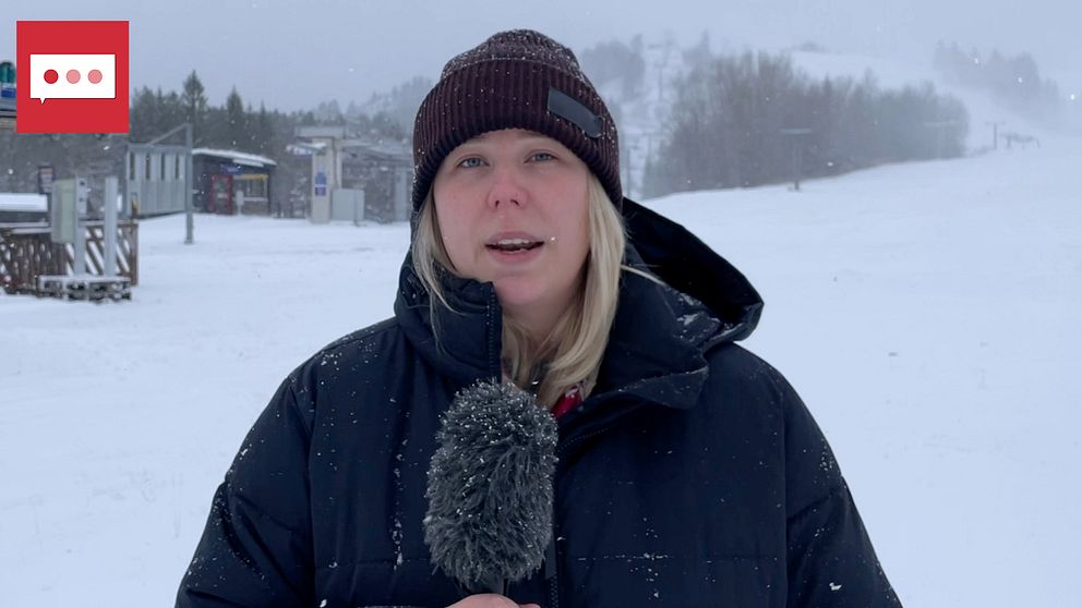 En kvinna med blont hår och svart mössa håller i en mikrofon