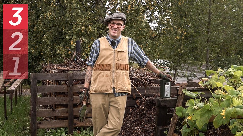 Trädgårdsmästaren Markus Rosendal står vid sin höstträdgård med olika växter och blommor i bakgrunden. Personen har på sig en rutiga skjorta och en väst.