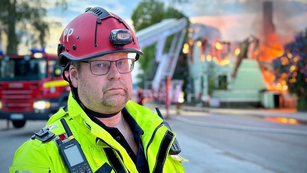 Räddningsledare Pär Palm framför brinnande hus i Bergsjö.