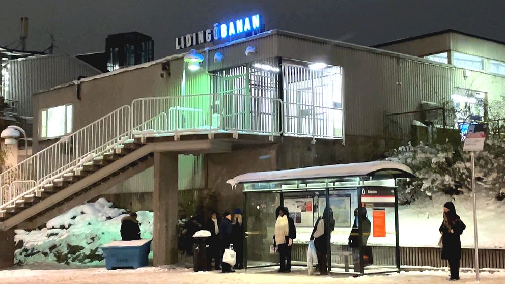 Resenärer i ett vinterkallt Ropsten väntar på bussen som ersätter Lidingöbanan
