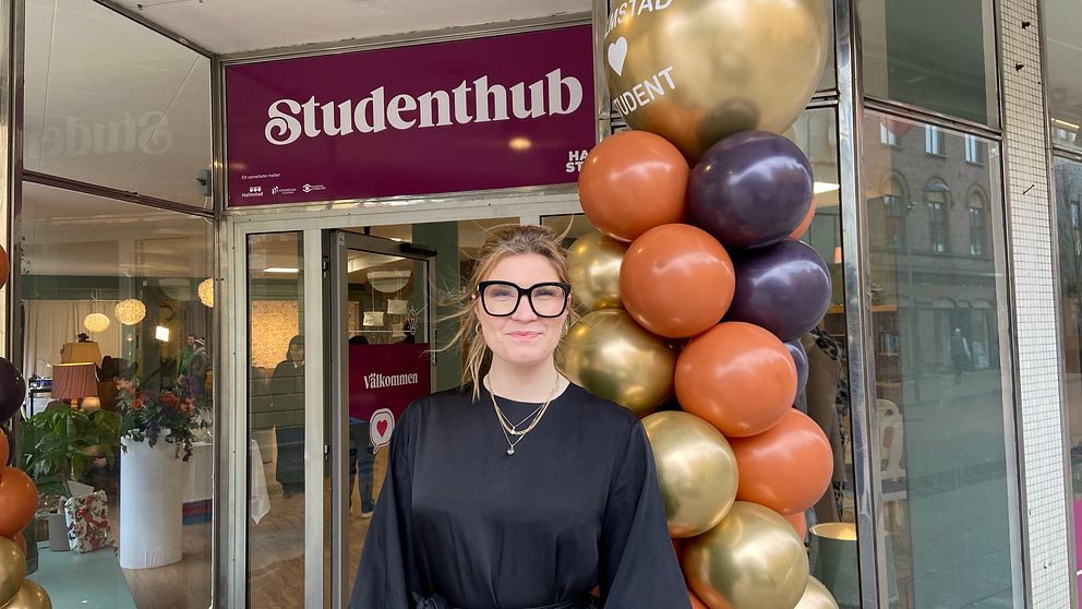 Studentkårens ordförande Linnea Håkansson står utanför studenthubben som är pyntat med ballonger.
