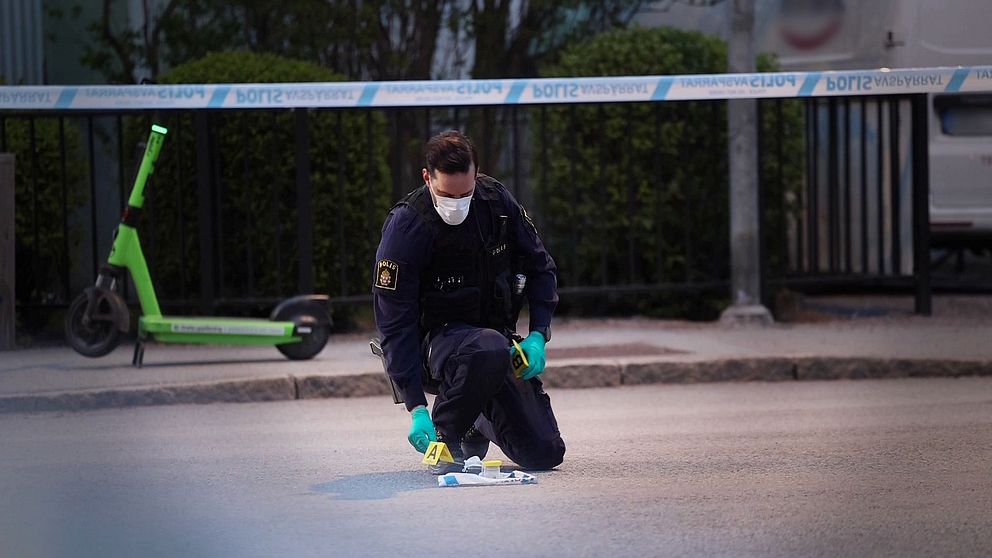 Polis undersöker avspärrad gata, elsparkcykel syns i bakgrunden.