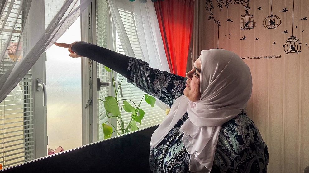 Amal Amad pekar på plasten som täcker fönstret.