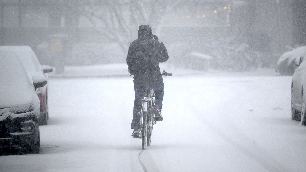 En cyklist som cyklar i snöoväder.