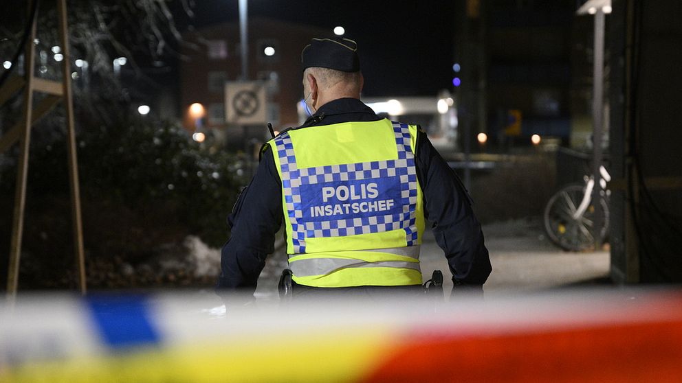 Polis utanför lägenheten där de två döda männen hittades.