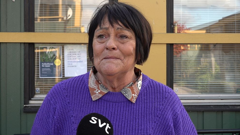 En äldre kvinna som ser ut att börja gråta i mörkt hår och lila tröja blir intervjuad i SVT