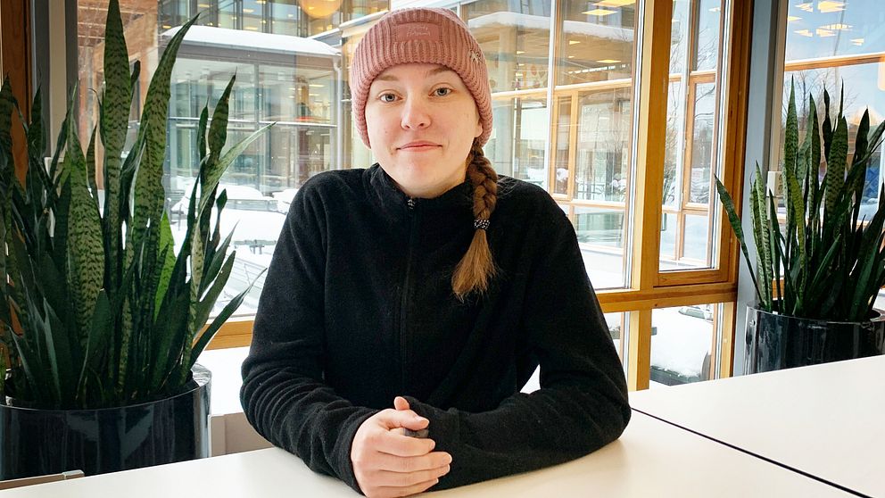 Student Emma Johansson sitter vid ett skrivbord på universitetet i Västerås.