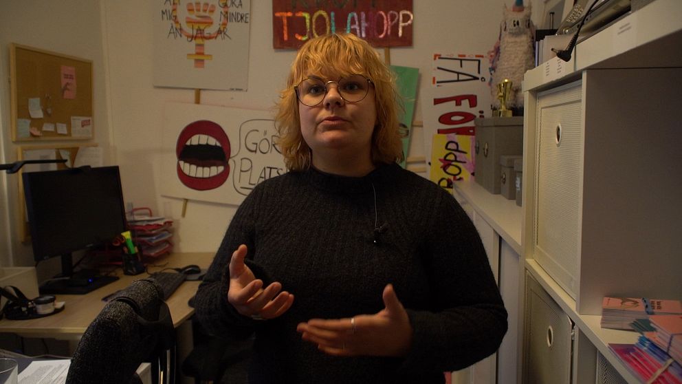 Kvinna framför plakat på kontor