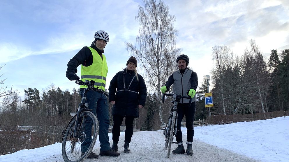 Cyklister står på en snöig väg.