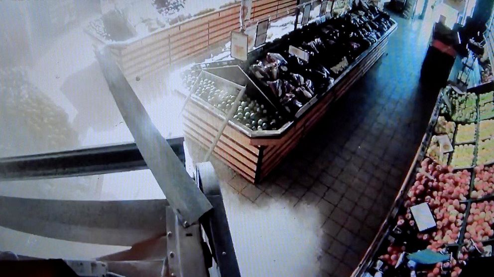 övervakningsbild över bomb som exploderar inne i butik. Grönsaksdisk syns