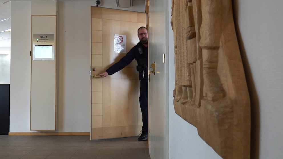Vakt som stänger dörren till sal 1 i Ångermanlands tingsrätt,