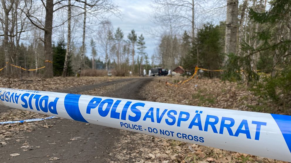 Polisens avspärrningsband med brandplats i bakgrunden