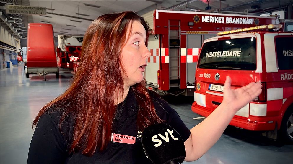 vakthavande befäl står i brandkårens vagnhall och blir intervjuad