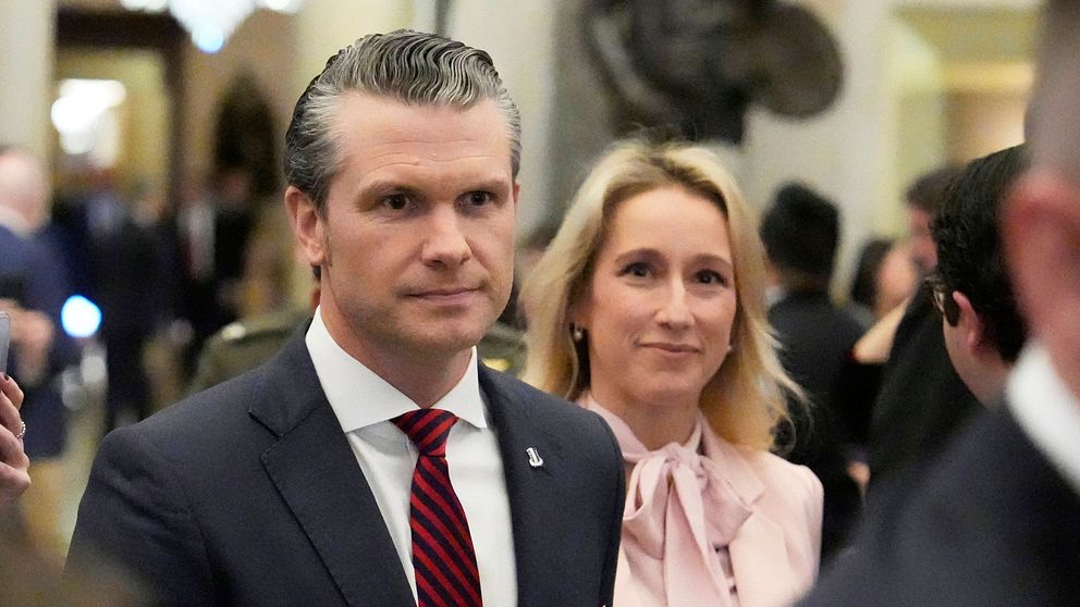 Välklädda personer minglar i en stor konferenshall.