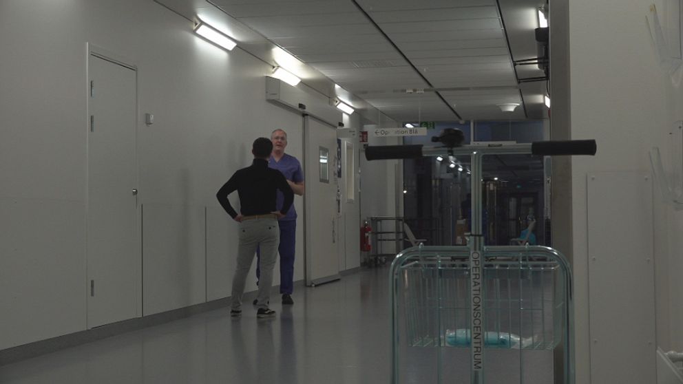 en korridor i centralsjukhuset i Karlstad, vita väggar, två personer stor emot varandra lite längre bort