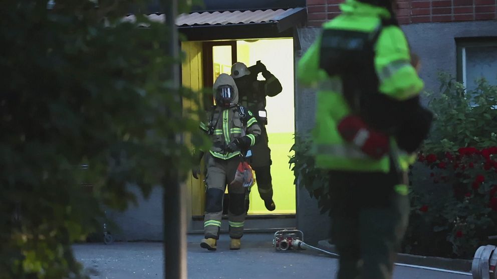 Rökdykare från räddningstjänsten lämnar bostadshus i Sollentuna efter detonation.