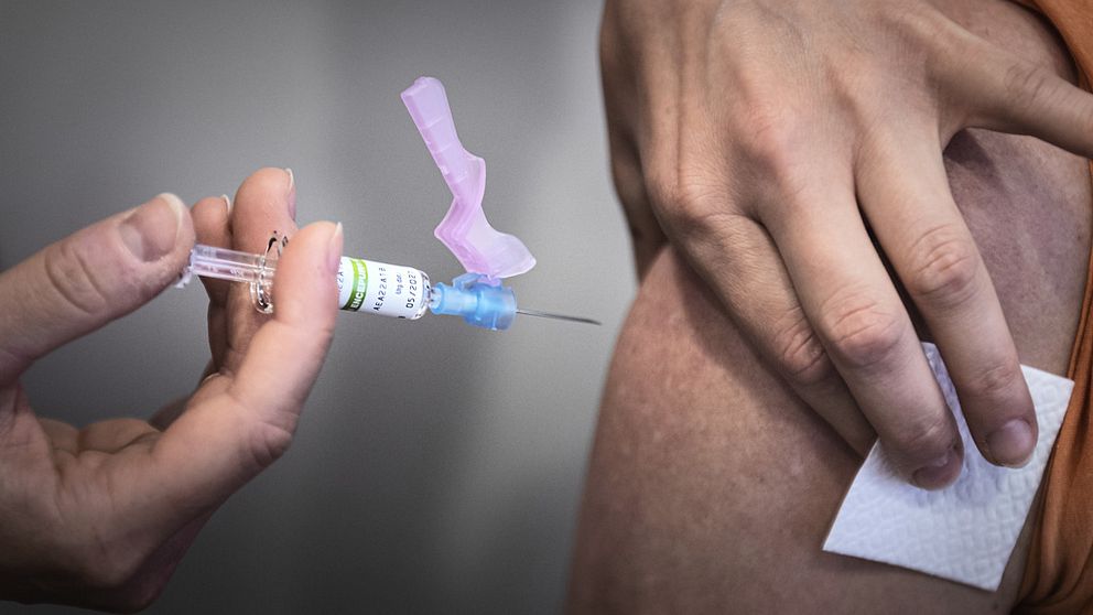 En spruta TBE-vaccin förs mot en arm
