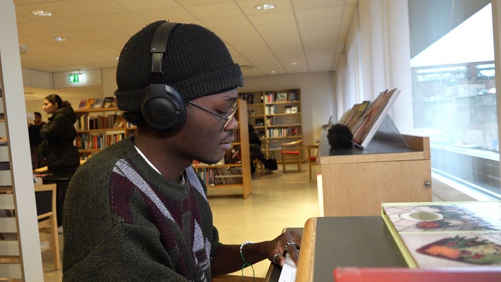 En student sitter och pluggar i biblioteket i Eskilstuna.