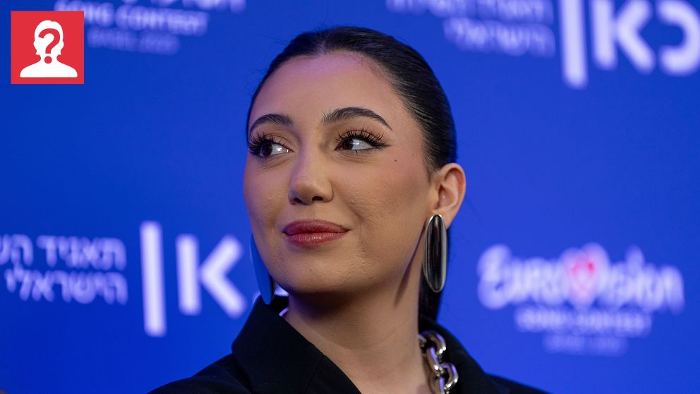 Person på presskonferens med Eurovision Song Contest-logga i bakgrunden.
