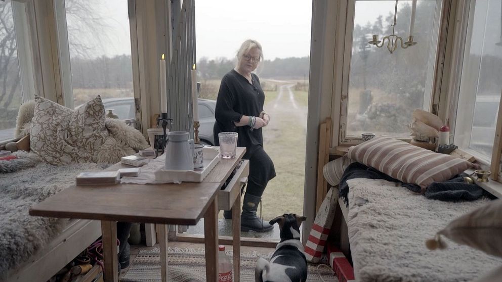 Rektor Anna står i entrén till en byggnad.