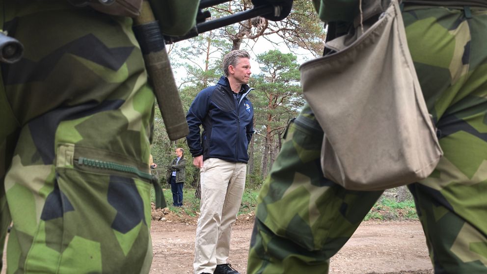 Försvarsminister Pål Jonson står framför en grupp soldater.