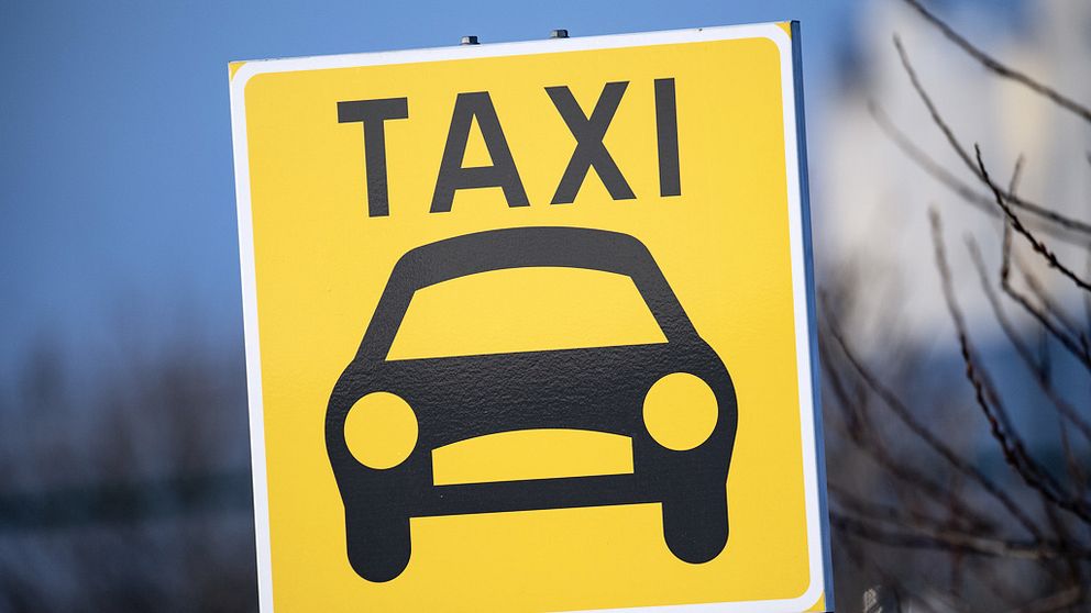En gul skylt med en bil och texten taxi.