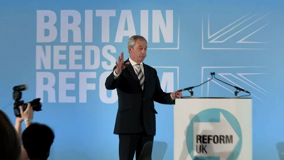Politiker talar vid podie med Reform UK-logga, texten ”Britain Needs Reform” syns bakom.