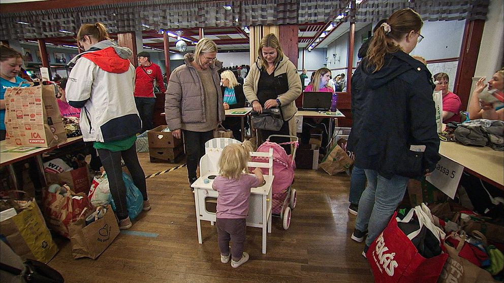 En familj med ett litet barn på stor barnloppis i Munkfors i Värmland.