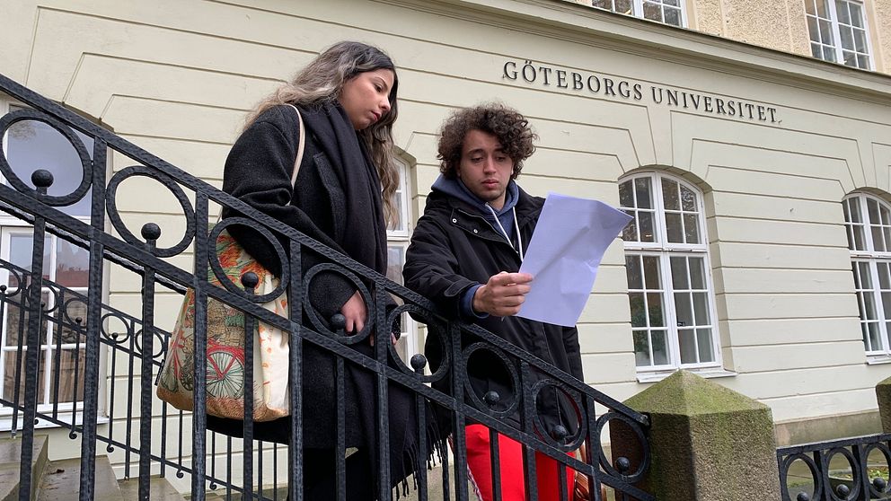 En kvinna och en man står och läser det öppna brev som studenter skrivit under på och som kräver bojkott av Israel.