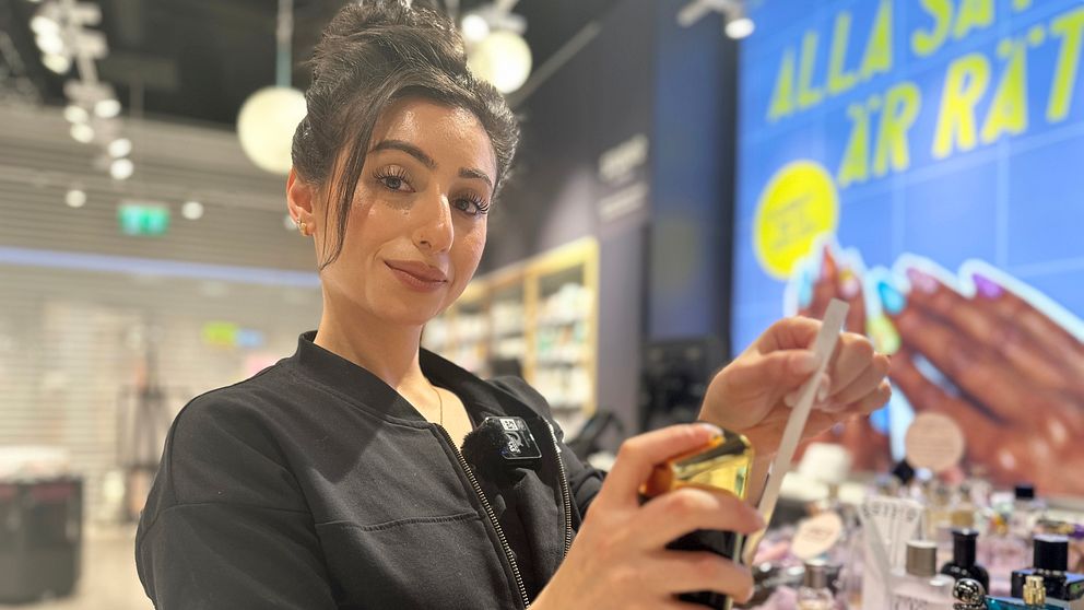 Butikschef Niveen Nouf på Lyko i Umeå sprutar en parfym som trendar på sociala medier