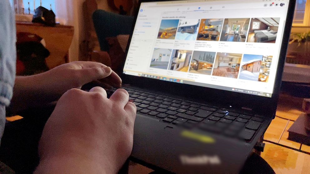 En person tittar på stugor på sociala medier framför en bärbar dator