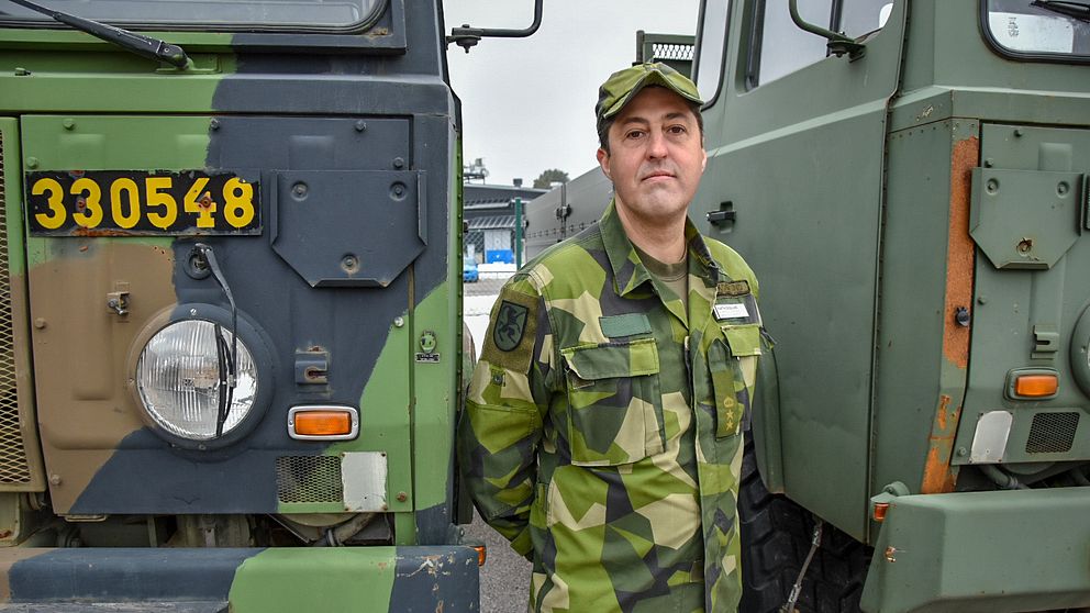 Martin Skoglund framför två militärfordon.