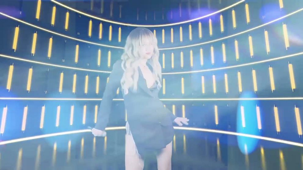 Emma Ejwertz står och framför Shake it off – Taylor Swift framför en skärm