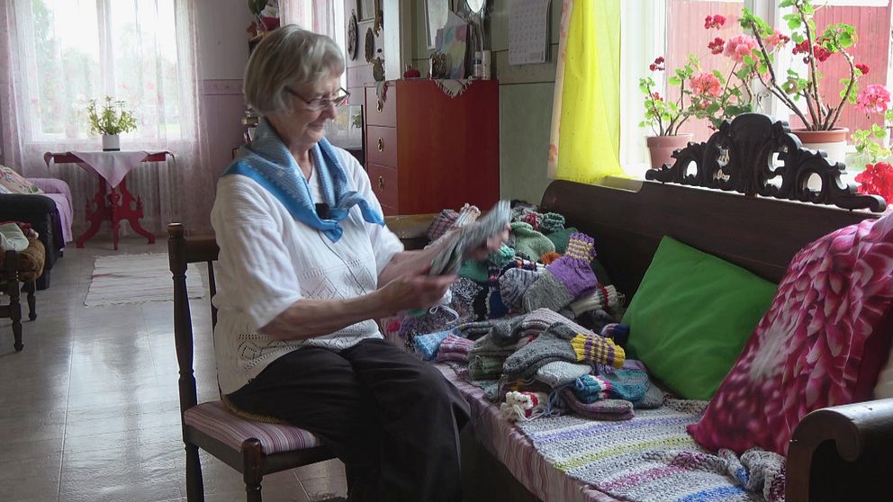 Ebba Hansson, 97 år,  visar upp sockarna hon har stickat för att skicka till Ukraina.
