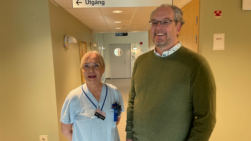 En kvinna och en man står bredvid varandra och ler.