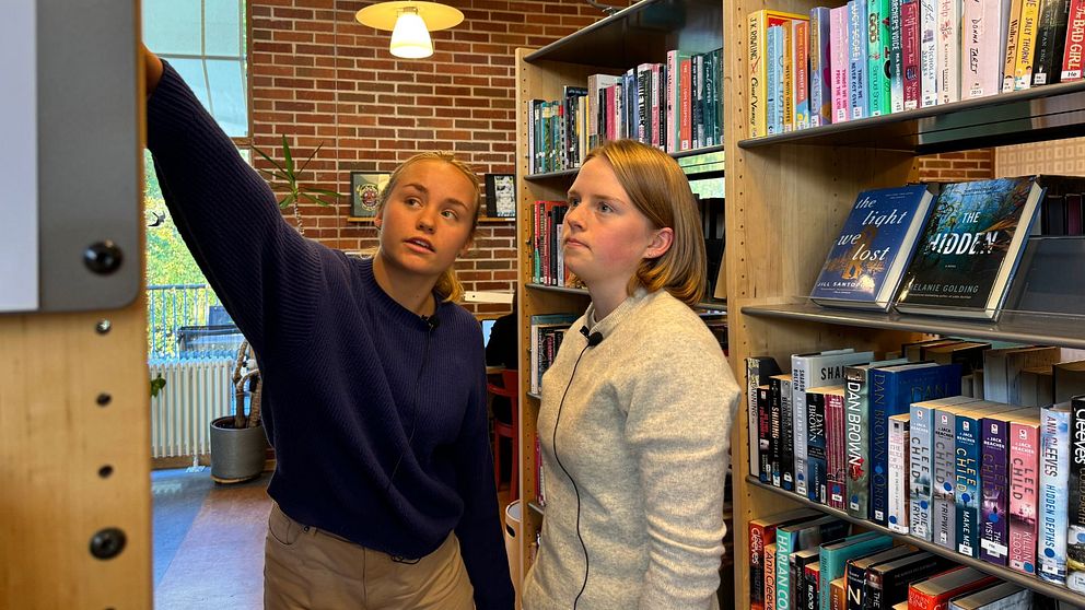 Alva och Kerstin Robinsson tittar på böcker på biblioteket i Eksjö.