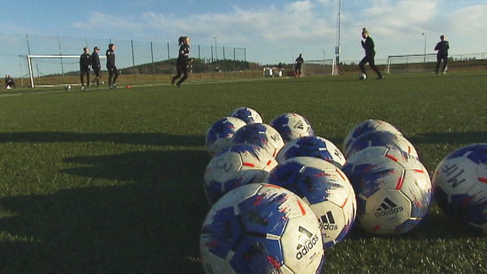 bollar i förgrunden och fotbollsspelare i bakgrunden