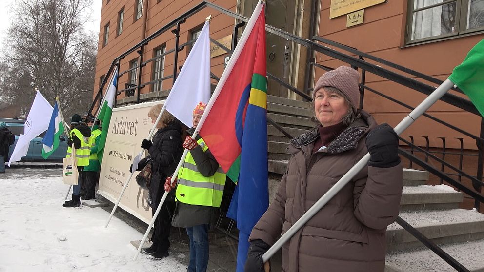 Personer demonstrerar utanför Riksarkivet med samiska och andra flaggor.