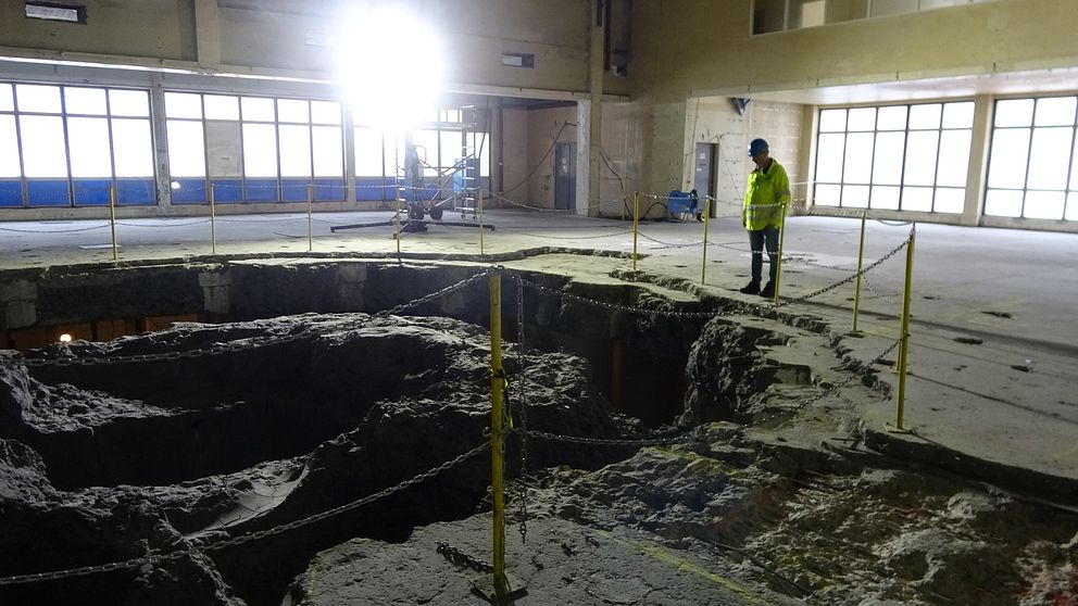 En man som står framför ett stort hål i betong, där en reaktor tidigare har varit.