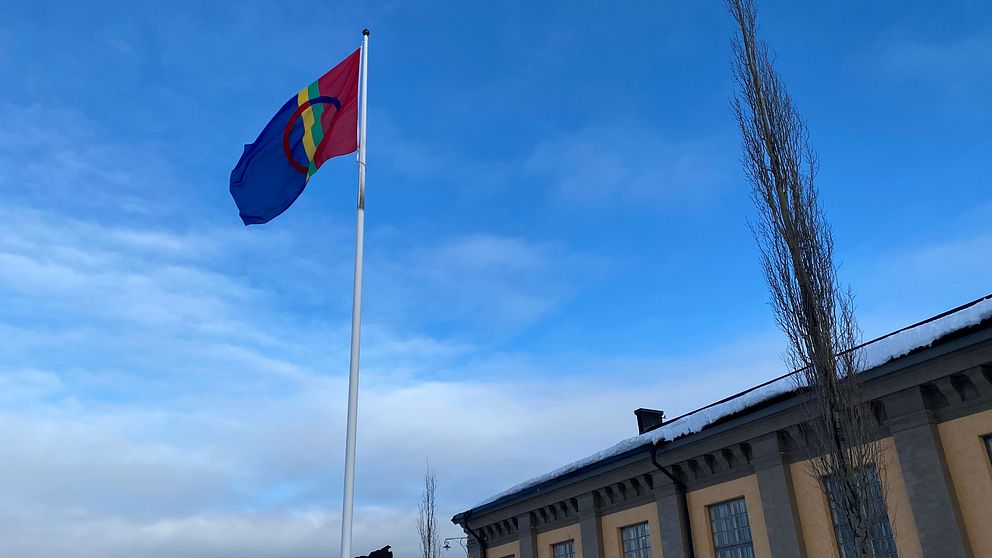 samisk flagga och husfasad i bakgrunden