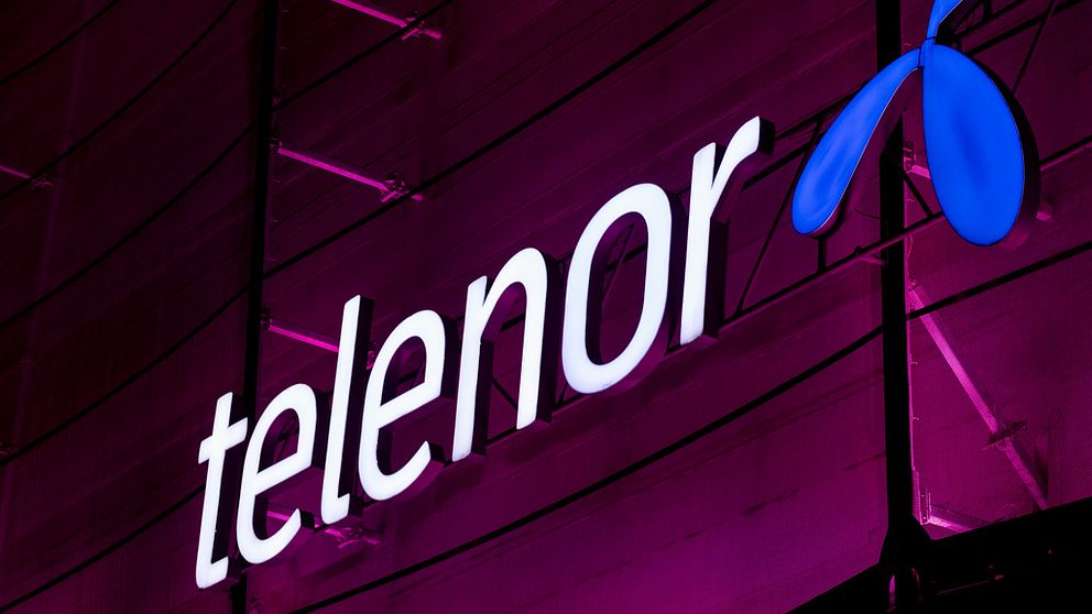Telenor-skylt mot en bakgrund med rosa lampor