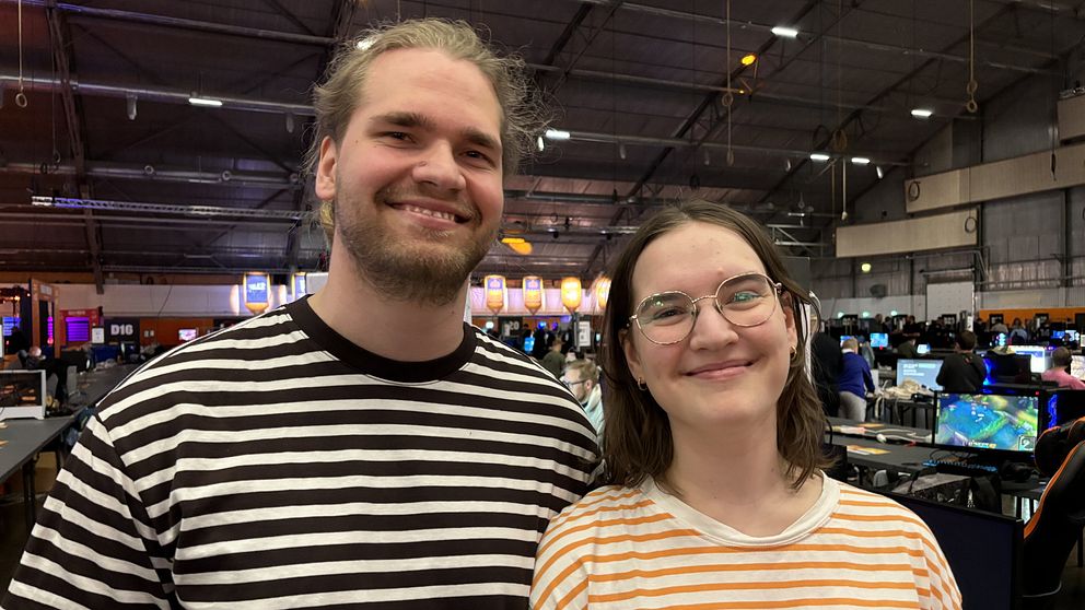 Johannes Rönndahl och Sara Wagner Rönndahl på gamingfestivalen Dreamhack. Johannes har en svart- och vitrandig tröja, och Sara har en orange- och vitrandig tröja.
