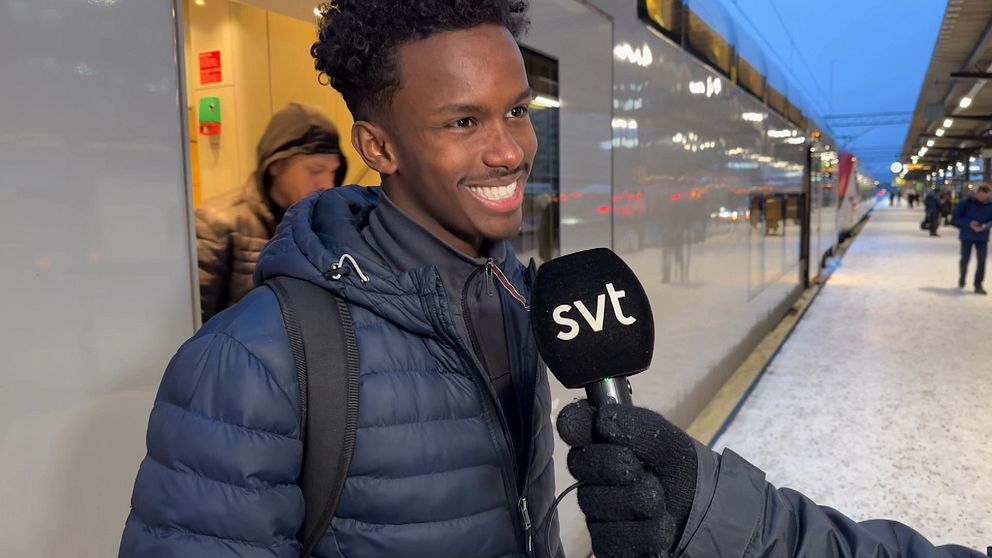 En ung man blir intervjuad vid sidan av ett tåg på Centralstationen i Örebro.